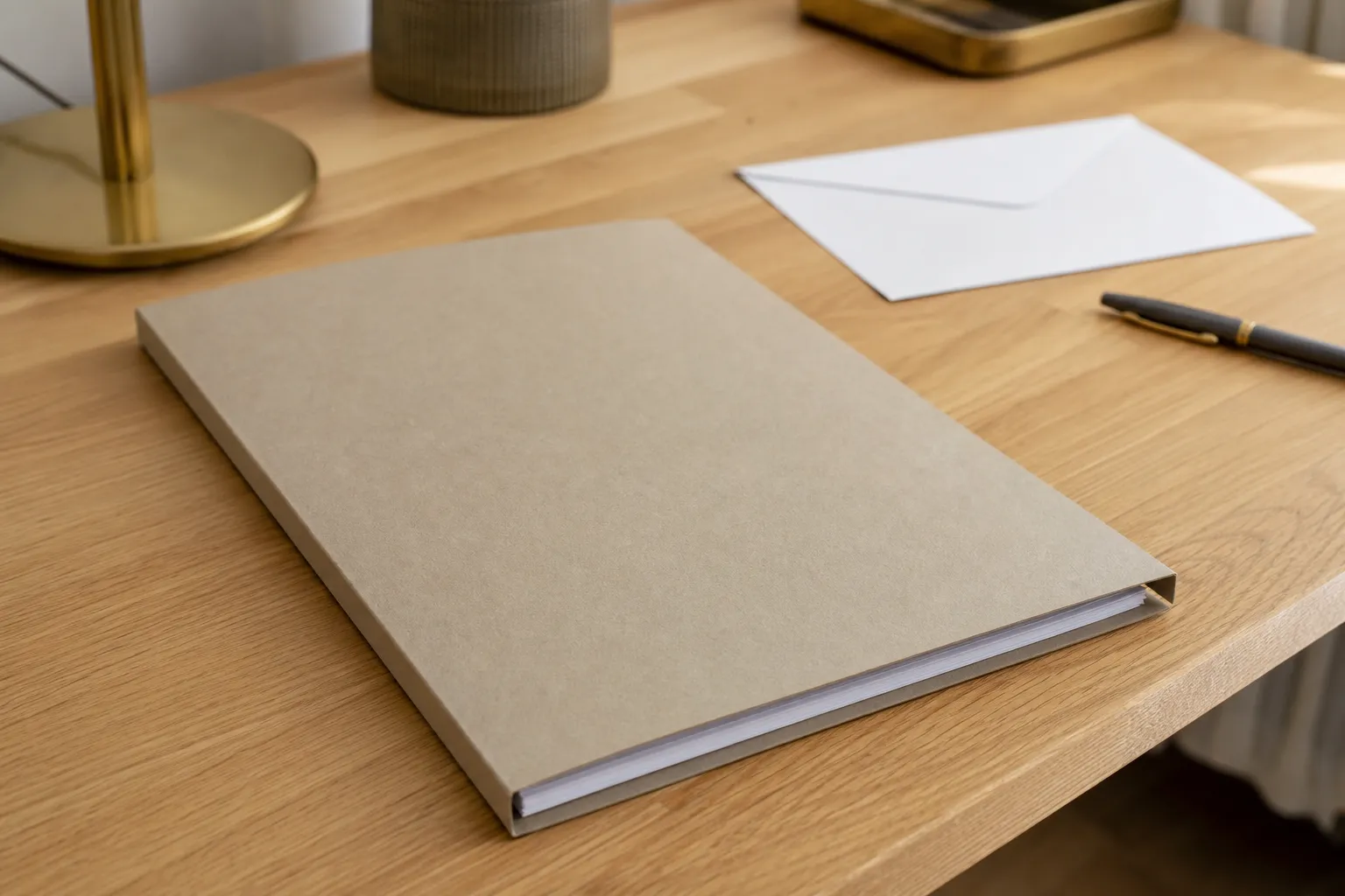 Chemise cartonnée fermée et enveloppe blanche vierge posées sur un bureau en bois clair